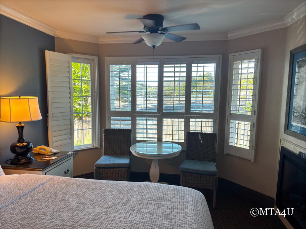 Cozy seating area by a large bay window in a guest room at Sand Pebbles Inn.