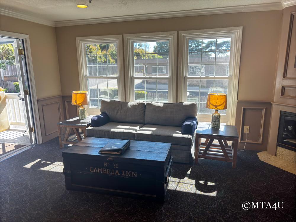 Cozy seating area in the lobby of Sand Pebbles Inn with large windows and warm lighting.