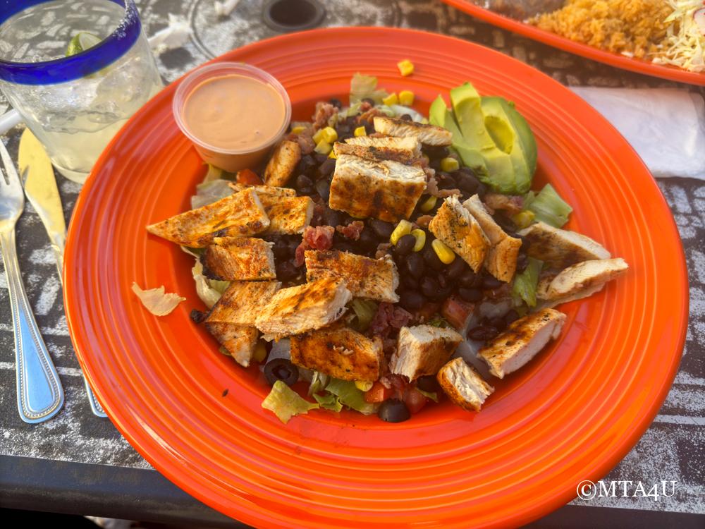 A colorful plate of Cambritas Chopped Salad with grilled chicken, avocado, black beans, and corn served at Las Cambritas in Cambria, California