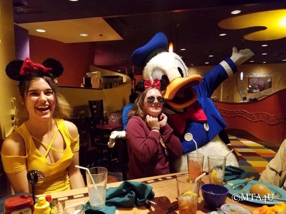 A lively gathering with Disney characters, creating a magical moment at a themed dining experience.