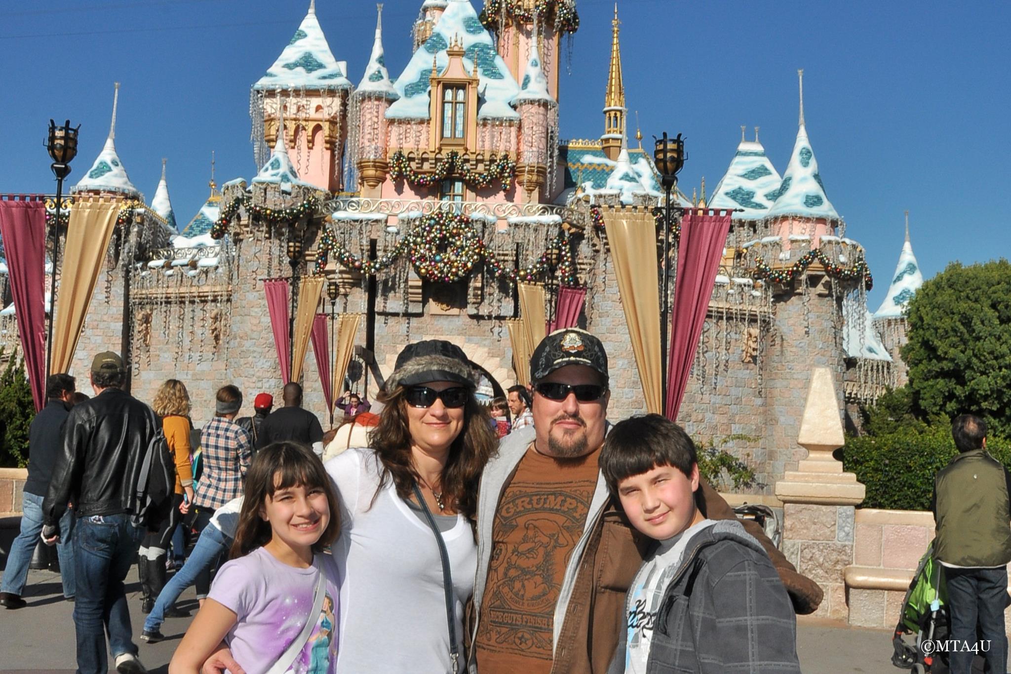 The iconic Sleeping Beauty Castle at Disneyland with MTA4U family in the foreground, representing travel and tourism.