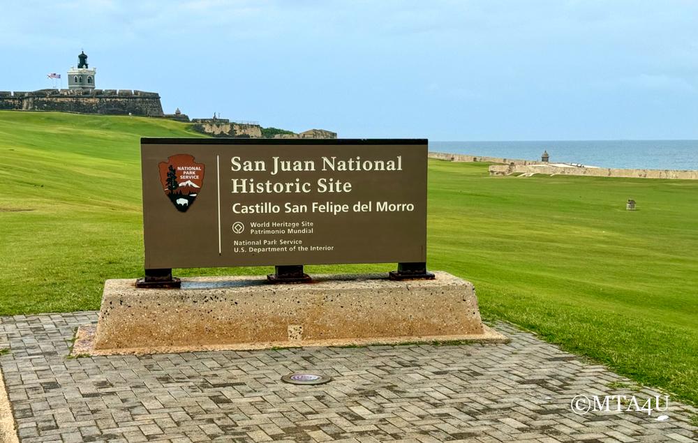 San Juan National Historic Site entrance sign with El Morro fortress in background, Puerto Rico.