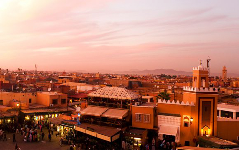 Sunset over Marrakech, Morocco, showcasing its iconic red-hued buildings and skyline.