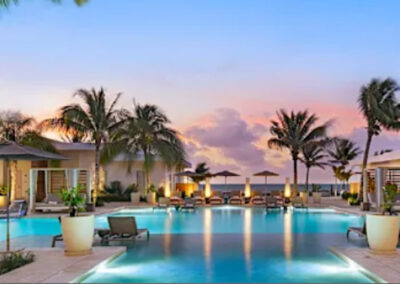 Belize All-Inclusive Resort Pool Area at Sunset - Mini Travel Adventures 4 Us Luxury beachfront pool with private cabanas and palm trees at sunset.