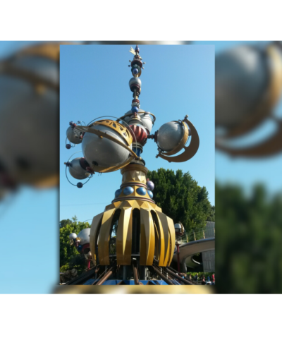 Astro Orbiter ride at Disneyland with planets and rockets in motion.