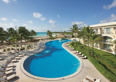 Aerial view of Dreams Tulum Resort & Spa's beachfront pool with ocean in background.