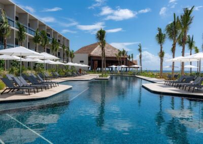 Main resort pool lined with palm trees and sun loungers.