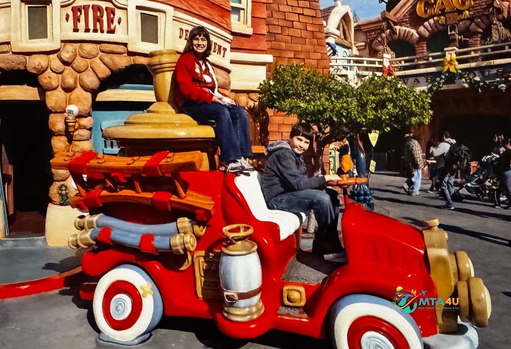 Kids on Cartoon Fire Truck at Disneyland Toontown (2012) Two kids smiling and posing on a red cartoon fire truck outside the Toontown Fire Department at Disneyland during a family vacation in 2012.