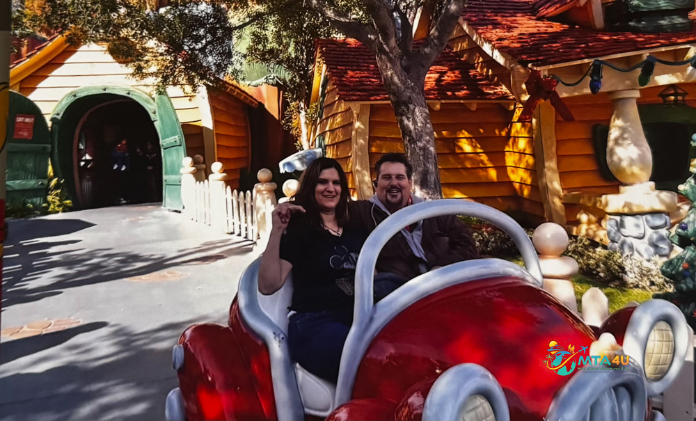 Couple Riding Cartoon Car in Disneyland Toontown Smiling couple enjoying a ride in a red cartoon-style car at Disneyland’s Toontown during their family vacation.