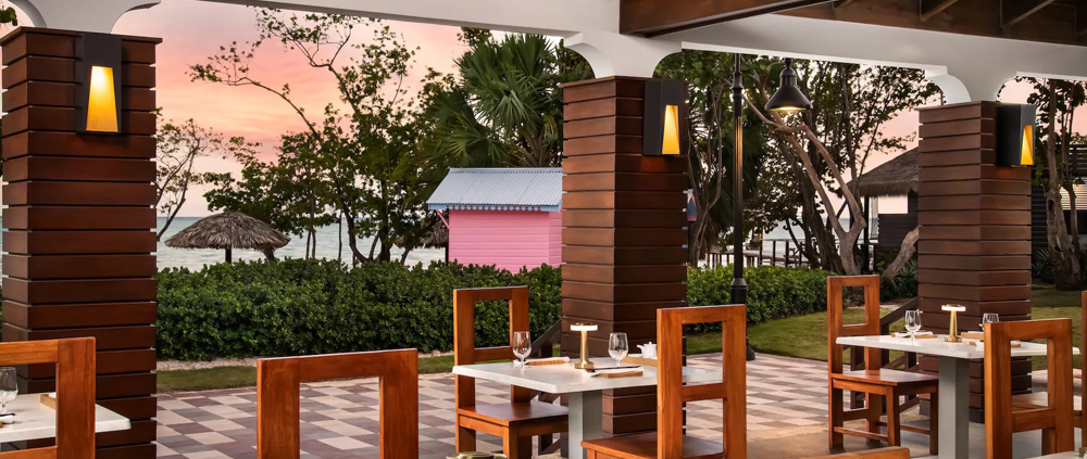 Oceanfront Dining at Sunset Elegant open-air dining setup at Sandals South Coast with ocean view.