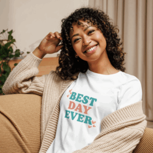 Smiling woman wearing a white Best Day Ever t-shirt with colorful lettering and hearts.