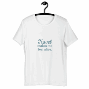 White “Travel Makes You Feel Alive” t-shirt on hanger.