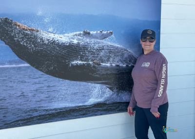 Mini Travel Adventures 4 Us at the Point Reyes Visitor Center, standing beside a whale mural during a Point Reyes day trip itinerary.