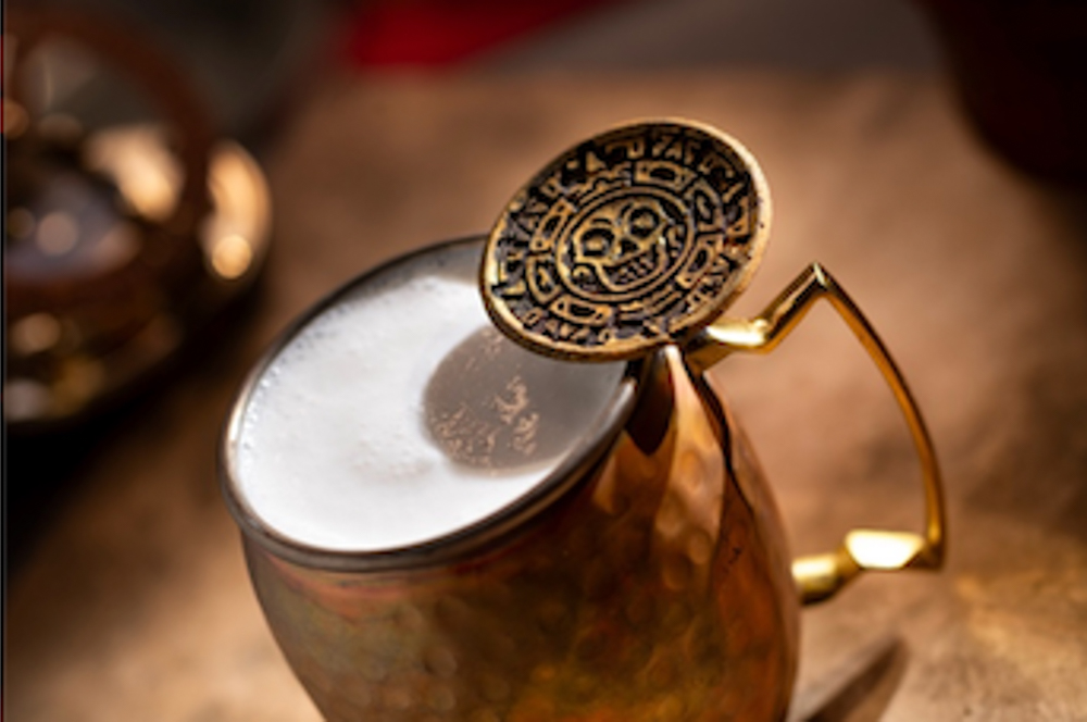 Cursed Treasure non-alcoholic drink at The Beak and Barrel with coconut milk, cookie crumbs, vanilla foam, and a pirate’s gold cookie.