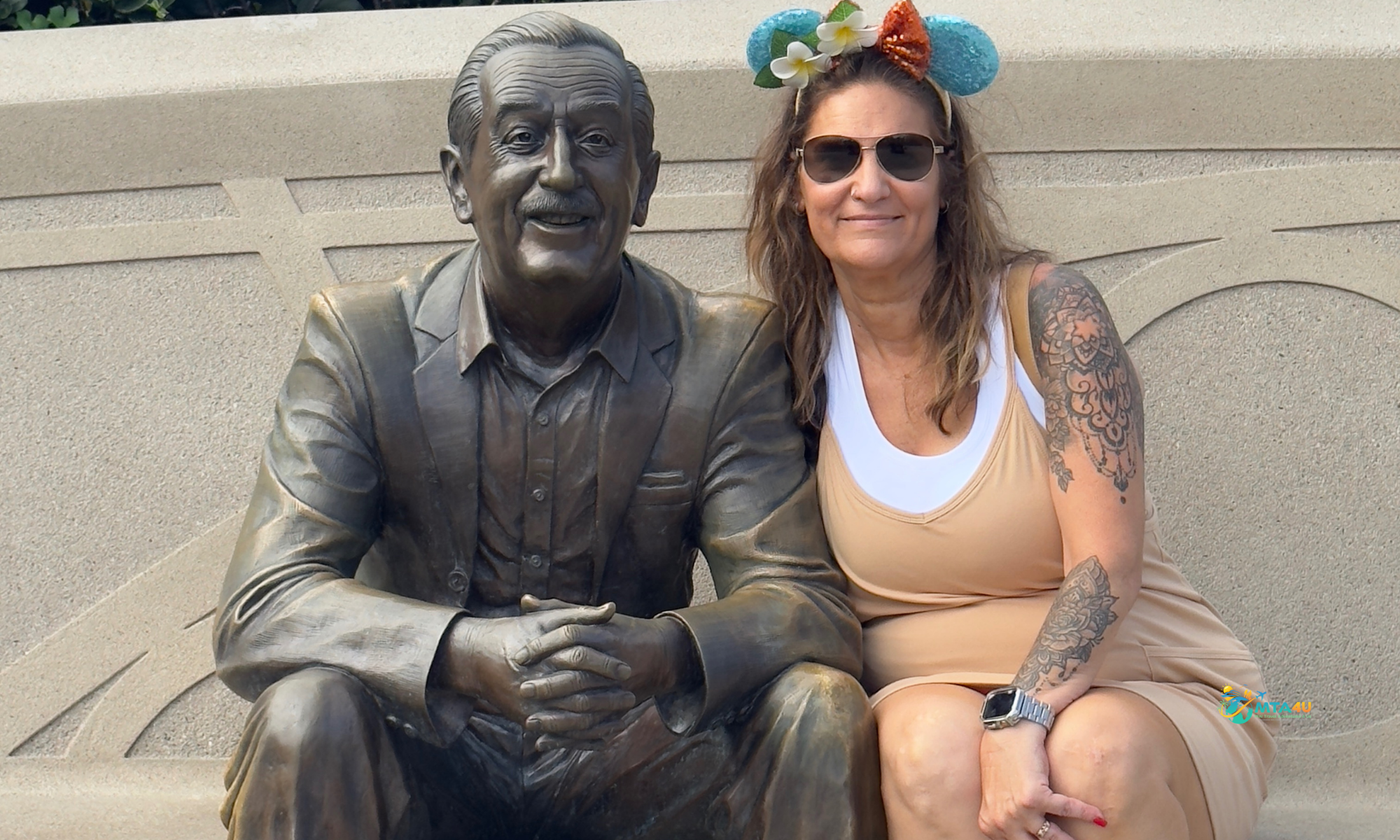 Noel Chapman sitting next to Walt Disney statue at Epcot in Walt Disney World.